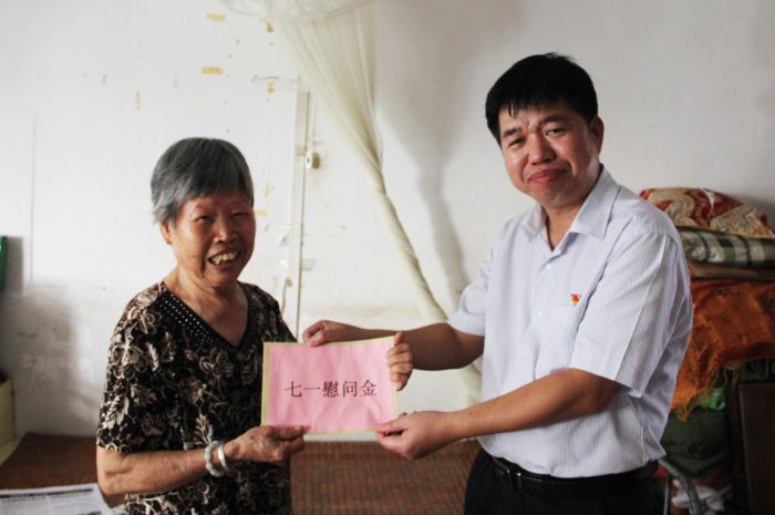 岑廷义将慰问金交到莫秋娇手中.jpg